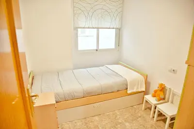 a small bedroom with a bed and a window at Apartamento Playa Xilxes in Xilxes