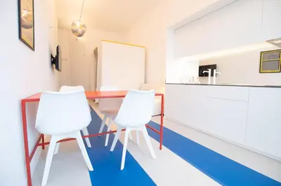 a kitchen with a table and two white chairs at Marino by Concept in Valencia