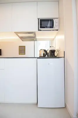 a small kitchen with white cabinets and a microwave at Marino by Concept in Valencia