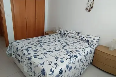 a bedroom with a bed with a blue and white blanket at Precioso apartamento en Canet d,en Berenger in Canet de Berenguer