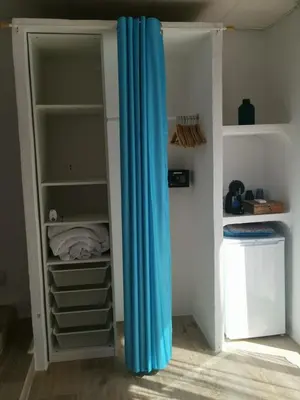 a closet with a blue curtain in a room at Relais Pollo Loco in Valencia
