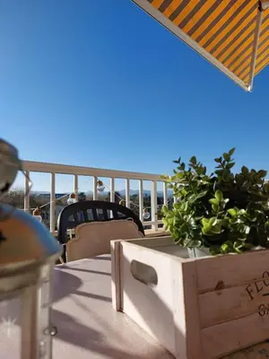 a wooden box with a potted plant on a balcony at CANET PLAYA MAGNIFICO APTO FAMILIAR con PISCINA y GARAJE in Canet de Berenguer