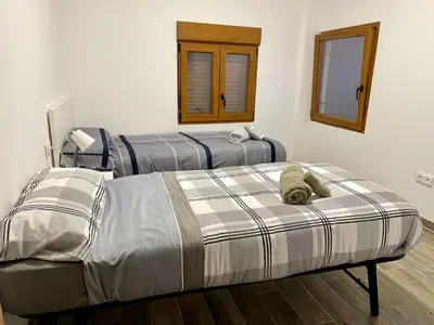 a bedroom with two beds and a mirror at Casa Rural Sarsalet in Chella