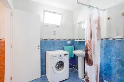 a bathroom with a washing machine and a sink at Casa con terraza en Sierra de Espadán in Vall de Uixó