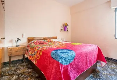 a bedroom with a large bed with a red blanket at Casa con terraza en Sierra de Espadán in Vall de Uixó