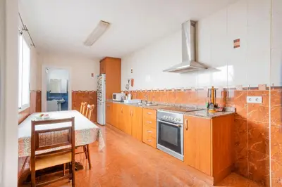 a kitchen with wooden cabinets and a table and a stove at Casa con terraza en Sierra de Espadán in Vall de Uixó