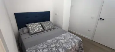 a small bedroom with a bed with a blue headboard at Apartamento 4 habitaciones 2 baños Ciudad de las Ciencias VT-55209-V in Valencia