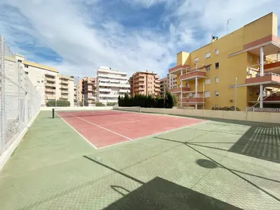 a tennis court in the middle of a city at Global Vacacional, Piso práctico, con terraza y piscina en la playa de Canet in Canet de Berenguer