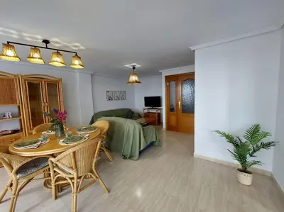 a living room with a table and a dining room at Vistas al mar en Canet Playa WIFI in Canet de Berenguer