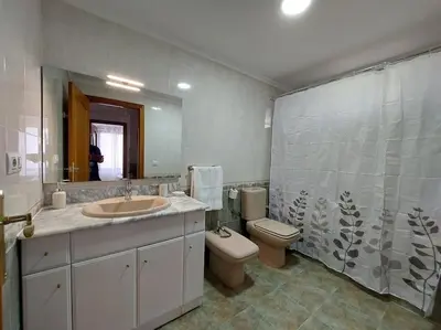 a bathroom with a sink and a toilet and a mirror at Vistas al mar en Canet Playa WIFI in Canet de Berenguer