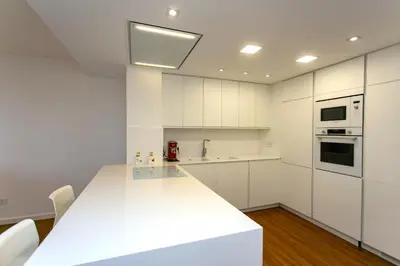 a kitchen with white cabinets and a white counter top at Cullera Beach Apartment Espacio in Cullera