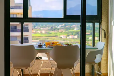 a dining room with a table and chairs and a window at Cullera Beach Apartment Espacio in Cullera