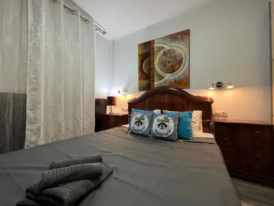 a bedroom with a large bed with blue pillows at Peset 69 in Valencia
