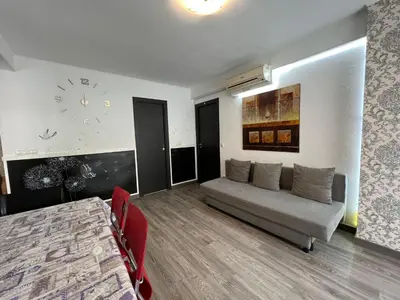 a living room with a couch and a clock on the wall at Peset 69 in Valencia