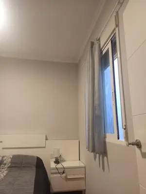 a white bedroom with a bed and a window at Vivienda Planta Baja in Algemesí