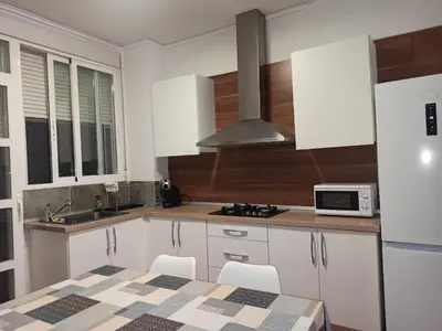 a kitchen with white cabinets and a sink and a microwave at Vivienda Planta Baja in Algemesí