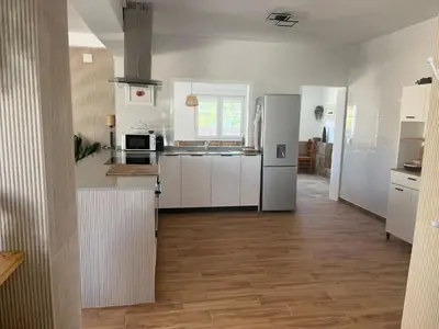 a kitchen with white appliances and a wooden floor at Casa de campo Ismael in Siete Aguas