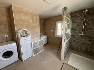 a bathroom with a washing machine and a shower at Casa de campo Ismael in Siete Aguas