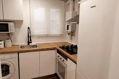 a white kitchen with a sink and a stove top oven at Alojamiento Náutico Junto a la Playa Malvarrosa in Valencia