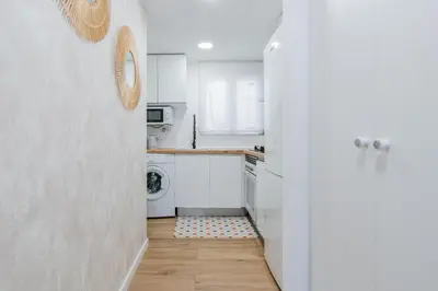 a kitchen with white cabinets and a washer and dryer at Alojamiento Náutico Junto a la Playa Malvarrosa in Valencia