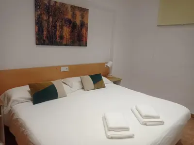 a white bed with two towels on top of it at Beach Nice Flat in Playa Pobla de Farnals