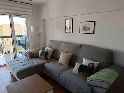 a living room with a gray couch with pillows at Beach Nice Flat in Playa Pobla de Farnals