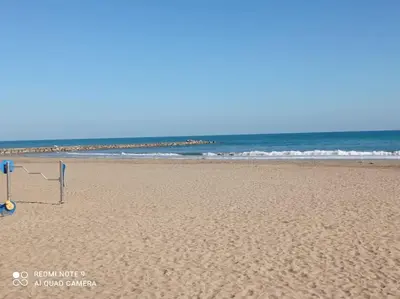 a beach with a net on the sand and the ocean at Beach Nice Flat in Playa Pobla de Farnals