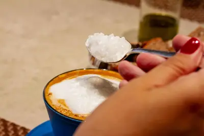a woman holding a spoon with a cup of sugar at La Novieta Boutique Hotel - Adults Only in Valencia