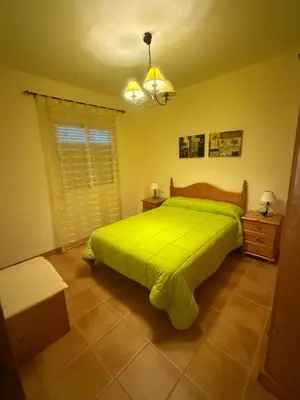 a bedroom with a green bed and a window at Duplex en Navajas (Castellón) in Navajas