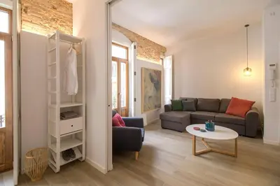 a living room with a couch and a table at Heart of trendy area of Russafa with lovely terrace ! au coeur de Ruzafa avec belle terrasse ! in Valencia