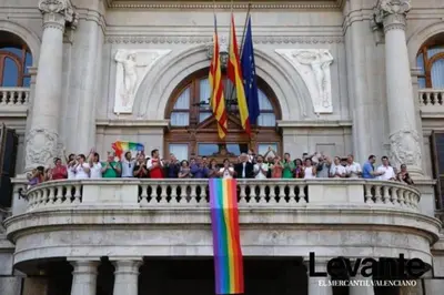 a group of people standing on a balcony with a rainbow flag at Heart of trendy area of Russafa with lovely terrace ! au coeur de Ruzafa avec belle terrasse ! in Valencia