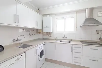 a white kitchen with white cabinets and a sink at Global Vacacional, Apartamento céntrico en Puerto de Sagunto para 5 personas in Puerto de Sagunto