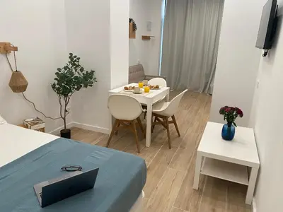a small room with a table and a white table and chairs at Travel Habitat Cabanyal Lofts in Valencia