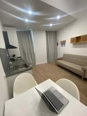 a living room with a table with a laptop on it at Travel Habitat Cabanyal Lofts in Valencia