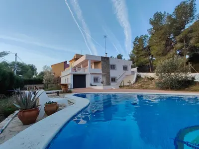 a villa with a swimming pool in front of a house at Fully private villa for 12p with large pool in Valencia-Náquera in Náquera