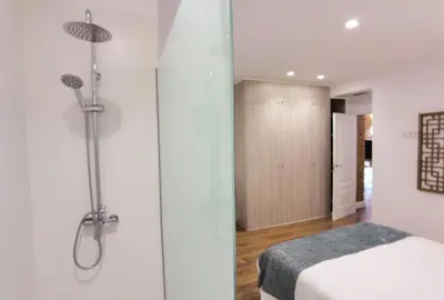 a bathroom with a shower and a bed in a room at Torres de Serranos Apartments - TTdSSa VLC in Valencia