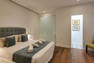 a bedroom with a large bed and a chair at Torres de Serranos Apartments - TTdSSa VLC in Valencia