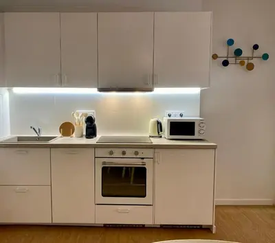a kitchen with white cabinets and a microwave at RIZADA RUZAFA in Valencia