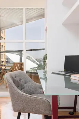 a chair sitting next to a desk with a laptop at Travel Hábitat L'Umbracle in Valencia