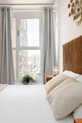a bedroom with a bed and a large window at Travel Hábitat L'Umbracle in Valencia