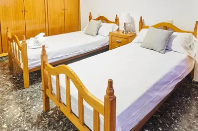 two twin beds in a room with wooden cabinets at EL RINCÓN VERDE in Puerto de Sagunto