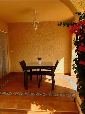 a table and chairs in a room with a plant at Adosado/casa con terraza y buhardilla. Playa El Perelló in El Perelló