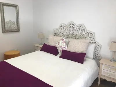 a bedroom with a large white bed with purple pillows at centrico cerca al ayuntamiento+luminoso+acogedor in Valencia