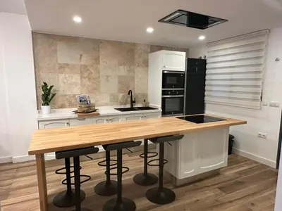 a kitchen with a wooden counter and stools in it at Vista Golf in Valencia