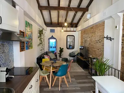 a kitchen and living room with a table and chairs at Hermoso flat de playa in Valencia