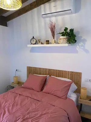 a bedroom with a bed with pink sheets and a shelf at Hermoso flat de playa in Valencia