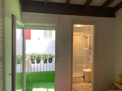 a bathroom with a sliding glass door with flowers on a fence at Hermoso flat de playa in Valencia