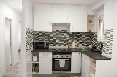 a white kitchen with a sink and a microwave at El Camino Del Mar in Valencia