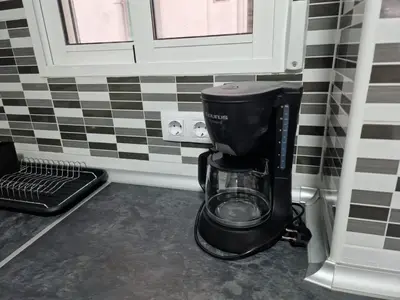 a black coffee maker in a corner of a kitchen at El Camino Del Mar in Valencia