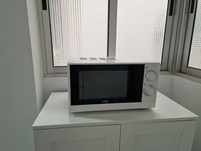 a microwave sitting on top of a white cabinet at El Camino Del Mar in Valencia
